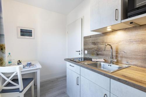 a kitchen with a sink and a desk with a chair at Friesenstube in Kerken
