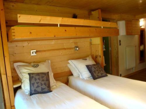 two beds in a room with wooden walls at Chambres d'hôtes le génépi in Valdeblore