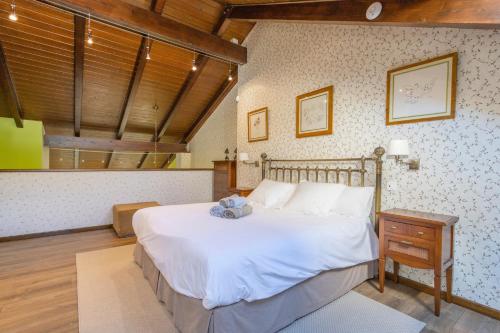 a bedroom with a large white bed and a wooden ceiling at Un duplex con encanto in Jaca