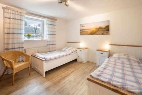 a bedroom with two beds and a window at Ferienwohnung Krempermoor 1 in Krempermoor