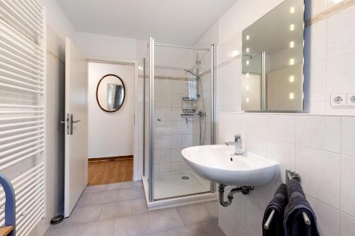 a white bathroom with a sink and a shower at Julia's Ferienwohnung in Gallin