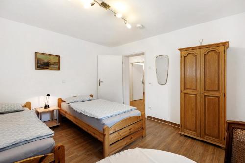 a bedroom with two beds and a wooden cabinet at Julia's Ferienwohnung in Gallin