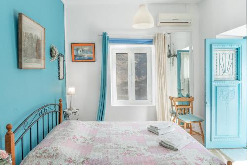 a bedroom with a bed and two windows at The Castle House Kea in Ioulis