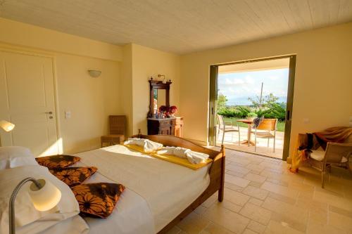 a bedroom with a bed and a door to a patio at Villa Kteni Ideales Resort in Kefallonia