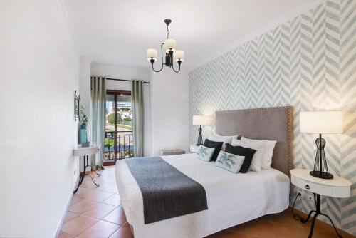 a bedroom with a large bed and a chandelier at Cosy Apartment with Pool 1 in Vilamoura