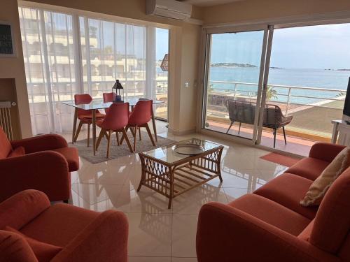 un soggiorno con tavolo e sedie e vista sull'oceano di Le Fourneau beach a Fréjus
