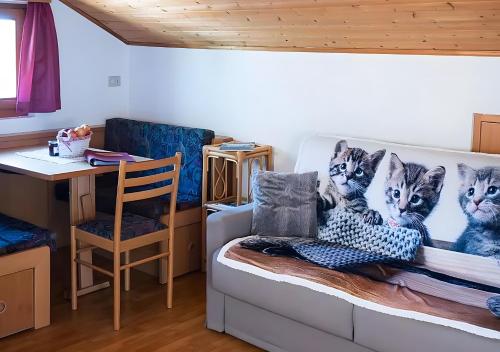 a room with a couch with a picture of three cats at Lechnerhof Appartement Alpenrose in Schenna