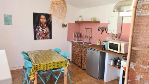 a small kitchen with a table and a microwave at Baobab Moz Lodge in Adail