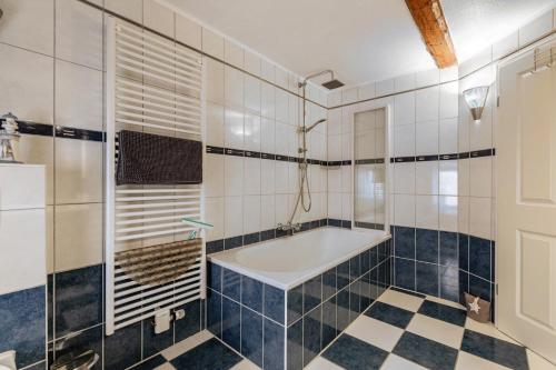 a bathroom with a tub and a tiled floor at Ferienwohnung Obenauf in Oesterwurth