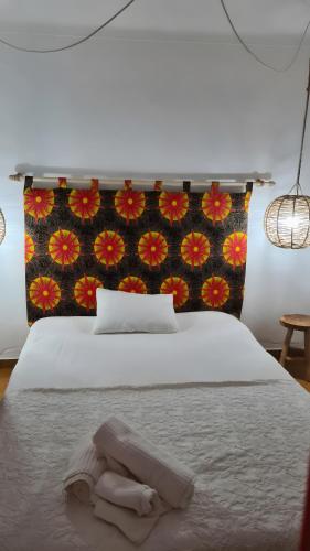 a bedroom with a white bed with a towel on it at Baobab Moz Lodge in Adail