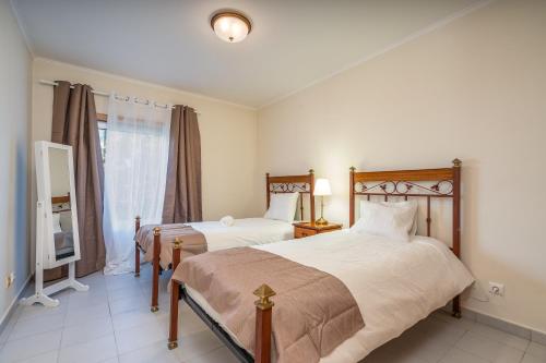 a bedroom with two beds and a window at Cool Motion Rocha Beach T2 in Portimão