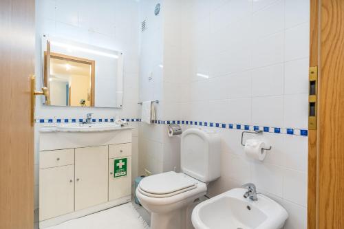 a white bathroom with a toilet and a sink at Cool Motion Rocha Beach T2 in Portimão