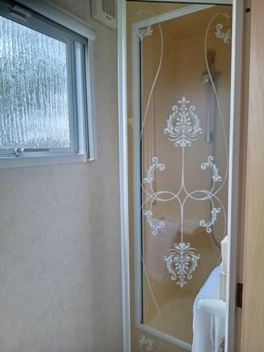 a shower with a glass door with a window at Agricamping Ca' Bodi Veneto in Cavallino-Treporti
