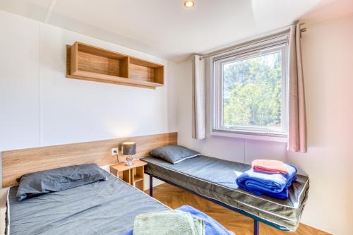 two beds in a room with a window at Le 370 Lattes in Lattes