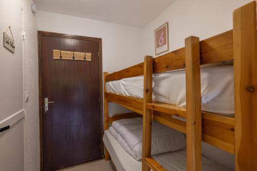 two bunk beds in a small room with a door at Les chalets du Praz 4 - Immoclean in Morillon