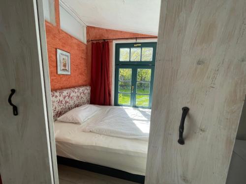 a small bedroom with a bed and a window at Ferienwohnung Teehaus in Saal