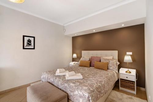 a bedroom with a large bed with two towels on it at Casa das Buganvilias in Loulé