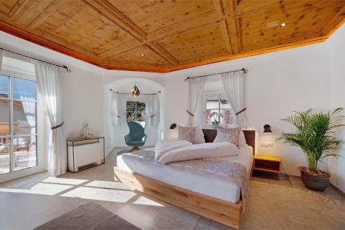 a bedroom with a large bed with a wooden ceiling at Engel Appartements Goschtstub in Parcines