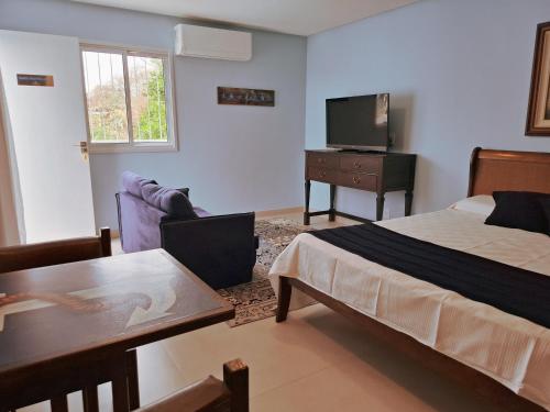 a bedroom with a bed and a table and a television at Quinta da Praia in Serra
