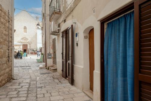 an alley in an old town with a church at L' Ippocampo in Polignano a Mare