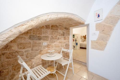 a room with a stone wall and a table and chairs at L' Ippocampo in Polignano a Mare