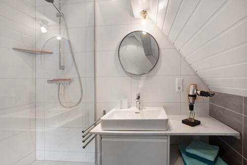 a white bathroom with a sink and a shower at Ferienwohnung Dashaus in Rheinfelden