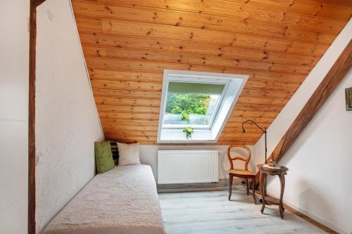 a attic room with a wooden ceiling and a window at Ferienwohnung Dashaus in Rheinfelden