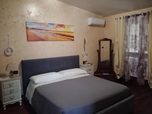 a bedroom with a blue bed and a mirror at I 4 mori in Fiumicino