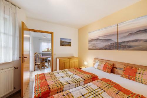 a bedroom with two beds and a dining room at Ferienwohnung am Steinbach in Albstadt