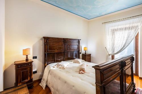 a bedroom with a large bed with a wooden headboard at L'antica Lugana front lake in Sirmione