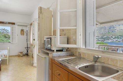 a kitchen with a sink and a microwave at Studio Telendos in Telendos