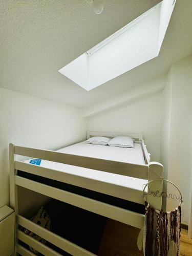 a bed in a room with a ceiling at Superbe duplex au pied de la plage in Mimizan