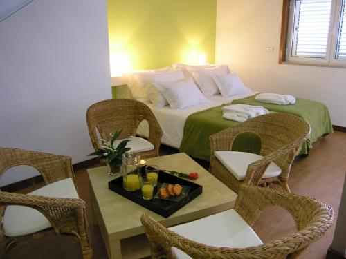 une chambre d'hôtel avec un lit et une table avec des chaises dans l'établissement Casa de Alpajares - Guest House & Spa, à Freixo de Espada à Cinta