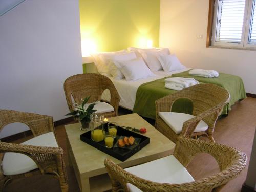 a hotel room with a bed and a table with chairs at Casa de Alpajares - Guest House & Spa in Freixo de Espada à Cinta