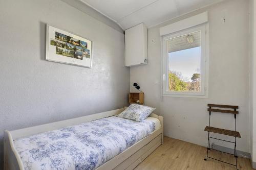 a small bedroom with a bed and a window at Le Gîte du Château Saint Ahon in Blanquefort