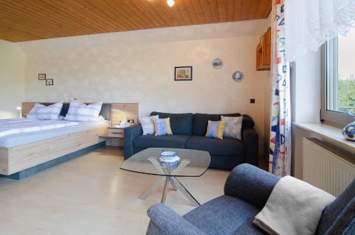 a living room with a couch and a bed at Enderle in Uhldingen-Mühlhofen