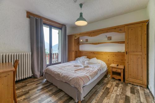 a bedroom with a bed and a large window at Chambre d'hôte Gite Passoud in Oz