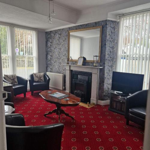 a living room with a fireplace and a television at New Hall Bank in Bowness-on-Windermere