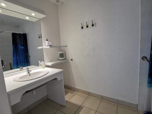 a white bathroom with a sink and a mirror at Maison dans résidence mer - piscine in Loc-Maria-Plouzané