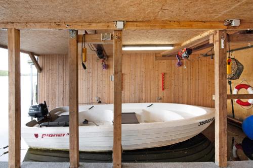 a white boat in a room with wooden walls at Bootshaus Am Müritzarm in Vipperow