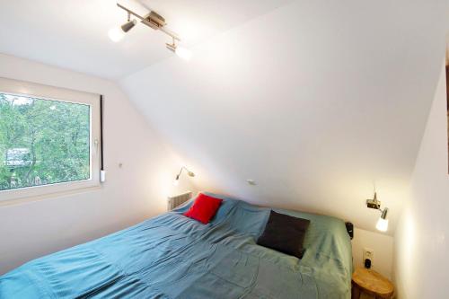 a bedroom with a blue bed and a window at Bootshaus Am Müritzarm in Vipperow