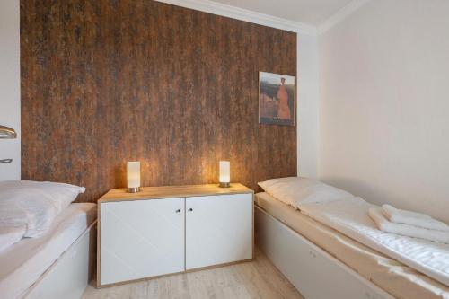 a bedroom with two beds and a wooden wall at Harz Stube in Goslar