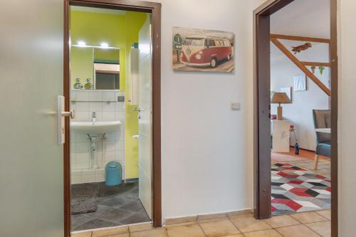a hallway with a bathroom with a sink and a mirror at Harz Stube in Goslar