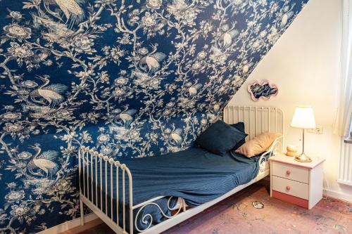 a bedroom with a crib with a blue and white wallpaper at Dahlienhof in Wittenberge
