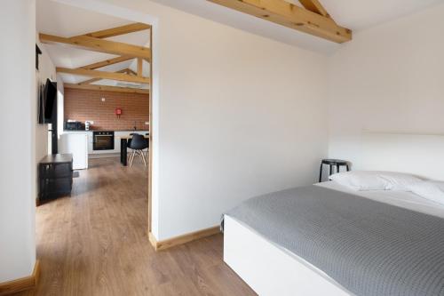 a bedroom with a bed and a kitchen in the background at Casa das Almas in Angra do Heroísmo