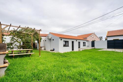 a yard with a picnic table and white buildings at Casa das Almas in Angra do Heroísmo