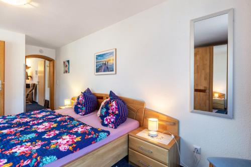 a bedroom with a bed with a blue blanket and a mirror at Haus Monika in Todtmoos