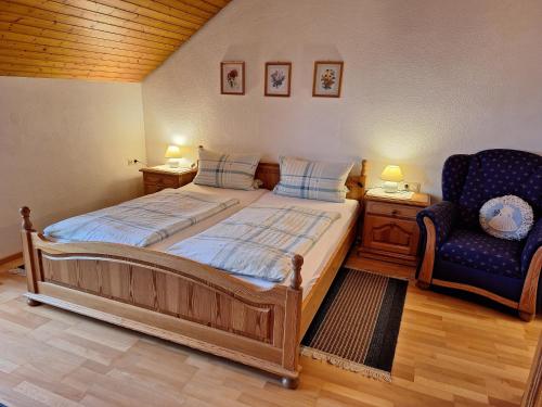 a bedroom with a bed and a blue chair at Christianshof in Oppenau