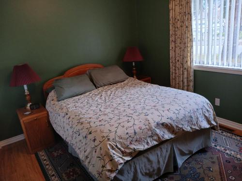 a bed in a bedroom with green walls at Grumpy's Suite by the Lake in Summerland