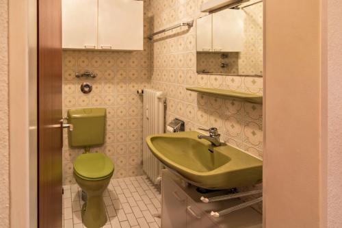a bathroom with a green toilet and a sink at Appartement Förster in Oy-Mittelberg